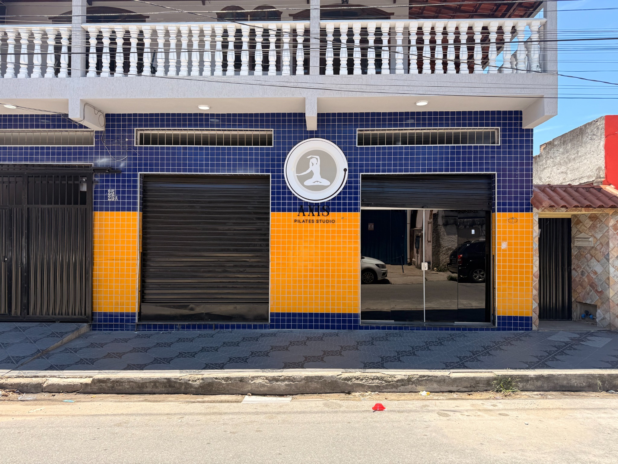 Fachada da AXIS Pilates e Fisioterapia, com identificação do estúdio e entrada de vidro